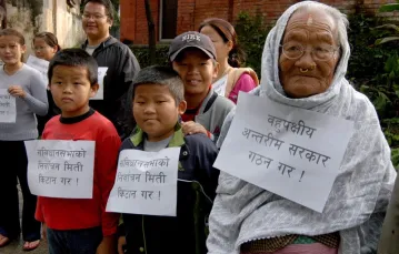 92-letnia Parbatee Rai z wnukami demonstruje przed rezydencją premiera w Katmandu, gdzie odbywały się rozmowy pokojowe. Napis na kartkach głosi: „Ustalcie datę wyborów do konstytuanty”. Nepal, 8 października 2006 r. / / fot. ASSOCIATED PRESS / FOTOLINK