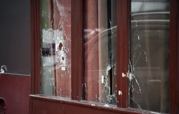 Podziurawiona kulami terrorystów witryna baru Carillon przy Rue Alibert w 10. dzielnicy Paryża. 14 listopada 2015 r. /  / fot. AFP / East News