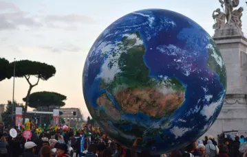 Ludzie niosą olbrzymi balon reprezentujący ziemię podczas wiecu wzywającego do działania w sprawie zmian klimatu, który odbył się dzień przed rozpoczęciem konferencji COP21 w Paryżu. Rzym, 29.11.2015 r. /  / TIZIANA FABI/AFP PHOTO/EASTNEWS