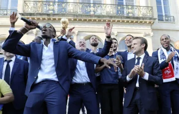 Paul Pogba (z mikrofonem) i pozostali reprezentanci Francji podczas przyjęcia przez Emmanuela Macrona (drugi z prawej) w Pałacu Prezydenckim, po powrocie drużyny ze zwycięskiego mundialu, 16 lipca 2018 / Fot. Ludovic Marin / AFP / East News / 