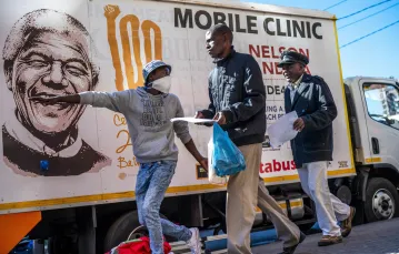 Wolontariusz kieruje mężczyzn do namiotu medycznego, gdzie zostaną przetestowani pod kątem COVID-19, a także HIV i gruźlicy, Johannesburg, 30 kwietnia 2020 r. / Fot. Jerome Delay / AP/Associated Press/East News / 