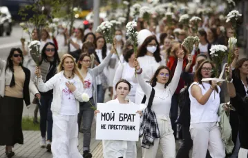 Białoruskie kobiety zbierają się w wielu miastach i miasteczkach, często z kwiatami w rękach. Funkcjonariusze nie używają wobec nich przemocy. Jedna z nich niesie plakat z napisem „Mój brat nie jest przestępcą”. Mińsk, 13 sierpnia 2020 r. /AP/East News / 