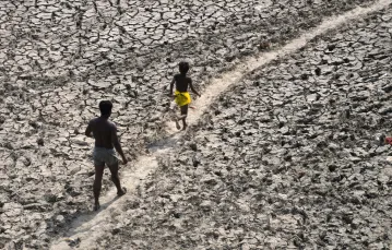 Mężczyzna i chłopiec spacerują po prawie doszczętnie wyschniętym korycie rzeki Yamuny. Nowe Delhi, Indie, 2 maja 2022 r. / FOT. Manish Swarup / AP/Associated Press/East News / 