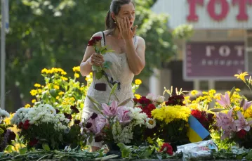 Kobieta składa kwiaty przed centrum handlowym w Krzemieńczuku, 29 czerwca 2022 r.29 czerwca 2022 r. / FOT. AP/Associated Press/East News / 