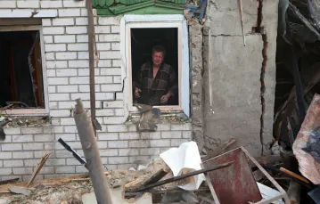 Roman Kravchenko w stoi w oknie swojego domu, który został zniszczony przez atak rakietowy na mieszkalne dzielnice Charkowa, 7 lipca 2022 r. / FOT. Vyacheslav Madiyevskyi/Ukrinform/East News / 