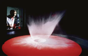 Badacz impaktów dr Pete Schultz przeprowadza symulację kolizji z ciałem niebieskim. W komorze próżniowej aluminiowy pocisk uderza z prędkością 1,8 km/s w barwiony piasek, tworząc krater i wzór rozprysku materii. Kalifornia, USA, 1985 r. / 