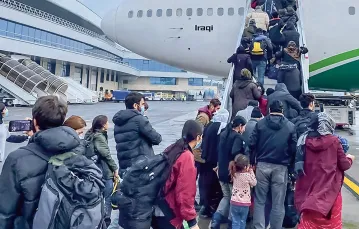 Irakijczycy i iraccy Kurdowie, którzy zdecydowali się wrócić z Białorusi do swojego kraju, wchodzą na pokład samolotu przysłanego po nich przez iracki rząd. Lotnisko w Mińsku, 18 listopada 2021 r. / fot. JAN HETFLEISCH / GETTY IMAGES / 