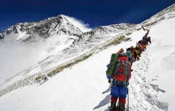 Kolejka na Mount Everest (widoczny po lewej). W majowym szczycie sezonu ustawia się w niej nawet ponad 100 osób dziennie. / Fot. Christian Kober / JAI / CORBIS