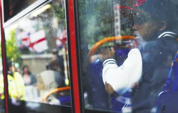 W londyńskim autobusie, maj 2013 r.; z lewej flagi Brytyjskiej Ligi Obrony, która po zamordowaniu żołnierza przez islamskich ekstremistów organizowała demonstracje w całym kraju. / Fot. Olivia Harris / REUTERS / FORUM