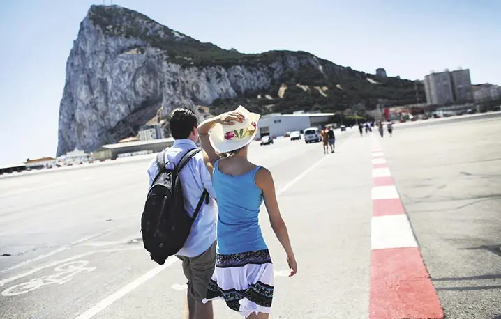 Wczasy pod „Skałą”: turyści przechodzą przez pas startowy lotniska w Gibraltarze. 7 sierpnia 2013 r. / Fot. Oli Scarff / GETTY IMAGES / FPM