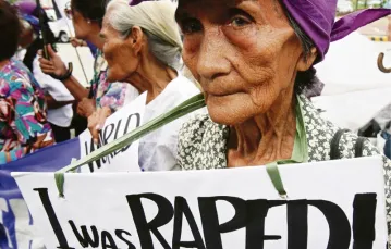 Filipinka Josefa Villamor, podczas II wojny światowej zmuszona do prostytucji przez japońskich żołnierzy, wraz z innymi ofiarami bierze udział w demonstracji przed ambasadą Japonii w Manili. Napis na transparencie: „Byłam gwałcona!”; marzec 2007 r. / Fot. Dennis M. Sabangan