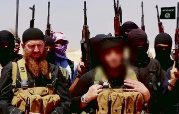Abu Omar al-Shishani i szejk Abu Mohammed al-Adnani (z wymaskowaną twarzą), dowódcy wojsk ISIS w prowincji Niniwa, 29 czerwca 2014 r. / Fot. Al-Itisam Media / AFP PHOTO / EAST NEWS