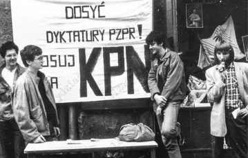 Członkowie KPN zbierają w Toruniu podpisy pod listą kandydatów Konfederacji przed wyborami czerwcowymi w 1989 r.; zdjęcie wykonane przez Służbę Bezpieczeństwa. / Fot. Archiwum IPN