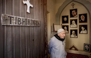 O. Jean-Pierre Schumacher, w tle portrety zabitych mnichów. Klasztor Notre Dame de l’Atlas, Midelt, Maroko, styczeń 2011 r. / Fot. Bruno Zanzottera / PARALLELOZERO
