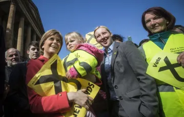 Nicola Sturgeon (z dzieckiem) i Mhairi Black (druga od prawej) w Paisley. Szkocja, kwiecień 2015 r. / Fot. Danny Lawson / PA / EAST NEWS