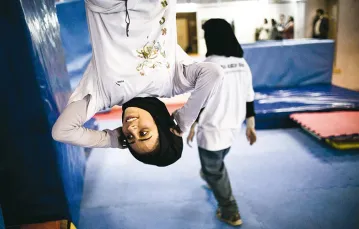 Irańska akrobatka Mahsa Khakbazan na co dzień uprawia parkour – pokonywanie miejskich przeszkód – z grupą podobnych jej kobiet z Teheranu, 2014 r. / Fot.Behrouz Mehri / AFP / EAST NEWS
