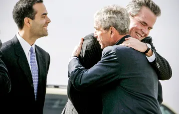Jeb Bush w uścisku brata, byłego prezydenta USA George’a W. Busha. Po lewej syn Jeba, George P. Bush. / Fot. Larry Downing / REUTERS / FORUM