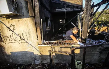 Izraelski policjant na zgliszczach palestyńskiego domu, spalonego przez żydowskich ekstremistów. Duma na Zachodnim Brzegu, 31 lipca 2015 r. / Fot. Abed Omar Qusini / REUTERS / FORUM