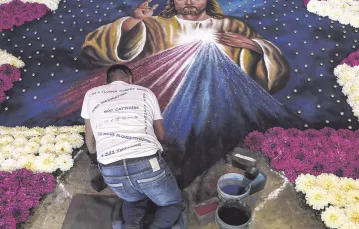 Obraz Jezusa Miłosiernego malowany farbami w proszku na asfalcie w Tlaxcala. Meksyk, 15 sierpnia 2016 r. / Fot. Hugo Ortuno / EPA / PAP