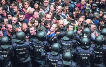 Policja hiszpańska otacza lokal wyborczy w Barcelonie, 1 października 2017 r. / ALBERTO ESTEVEZ / EPA / PAP