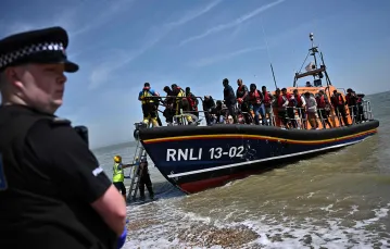 Kuter Royal National Lifeboat Institution z imigrantami przybija do wybrzeża Anglii niedaleko Dungeness, czerwiec 2022 r. // Fot. Ben Stansall / AFP / East News