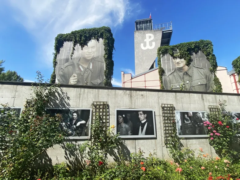 Ogród z muralami przy Muzeum Powstania Warszawskiego. Po drugiej stronie ściany pamięci znajdują się nazwiska zidentyfikowanych poległych. Lipiec 2024 r. // Fot. Patrycja Bukalska