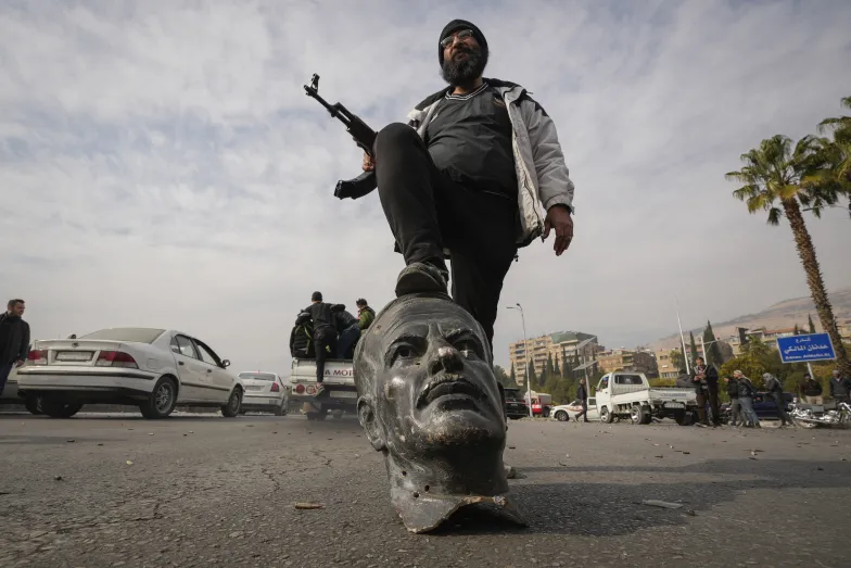 Partyzant nad obalonym pomnikiem Asada. Damaszek, 8 grudnia 2024 r. // Fot. Hussein Malla / Associated Press / East News Partyzant nad obalonym pomnikiem Asada. Damaszek, 8 grudnia 2024 r. // Fot. Hussein Malla / Associated Press / East News