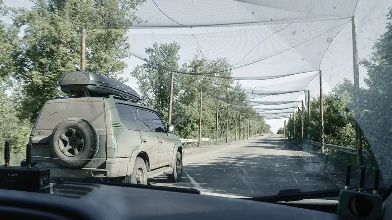 Siatka zabezpieczająca przed atakami dronów "drogę życia" pomiędzy Pokrowskiem a Rodyńskie. 23 maja 2025 r. // Fot. Jonasz Chlebowski Siatka zabezpieczająca przed atakami dronów "drogę życia" pomiędzy Pokrowskiem a Rodyńskie. 23 maja 2025 r. // Fot. Jonasz Chlebowski