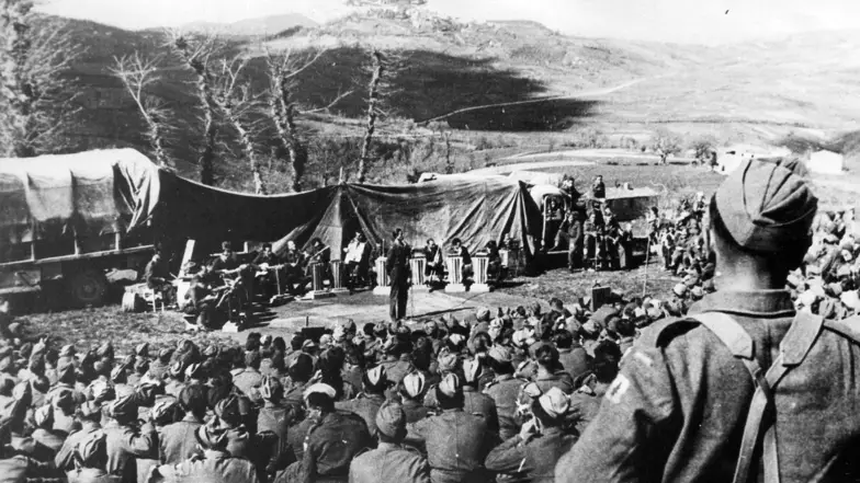 Gwidon Borucki (na scenie w głębi kadru) po raz pierwszy wykonuje piosenkę „Czerwone maki”. Włochy, maj 1944 r. // Narodowe Archiwum Cyfrowe Gwidon Borucki (na scenie w głębi kadru) po raz pierwszy wykonuje piosenkę „Czerwone maki”. Włochy, maj 1944 r. // Narodowe Archiwum Cyfrowe