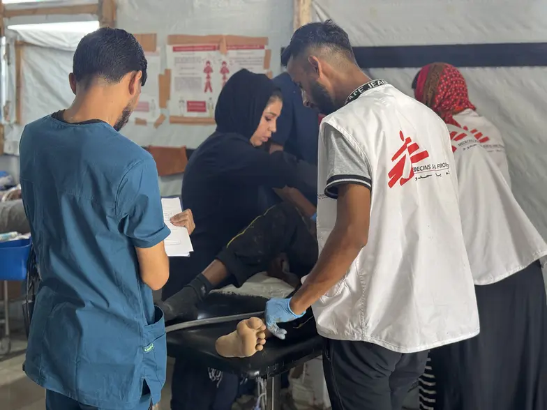 Zespół Lekarzy bez Granic zajmuje się pacjentem z ranami postrzałowymi w przychodni w Al Mawasi. Strefa Gazy, 2025 r. // Fot. Nour Alsaqqa / MSF