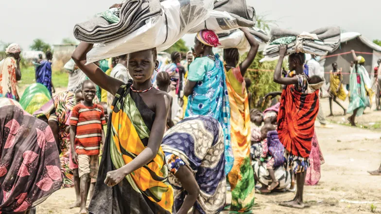 Uciekinierzy ze zniszczonej miejscowości Gumuruk otrzymują pomoc humanitarną w okolicy lądowiska w Piborze. Sudan Południowy, 2021 r. / fot. Natalia Ojewska