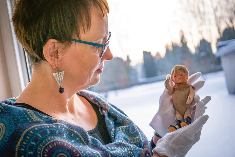 Marta Grudzińska, historyk z Państwowego Muzeum na Majdanku, z lalką znalezioną na terenie dawnego obozu. / IZABELA TOMASIEWICZ / ZBIORY PAŃSTWOWEGO MUZEUM NA MAJDANKU