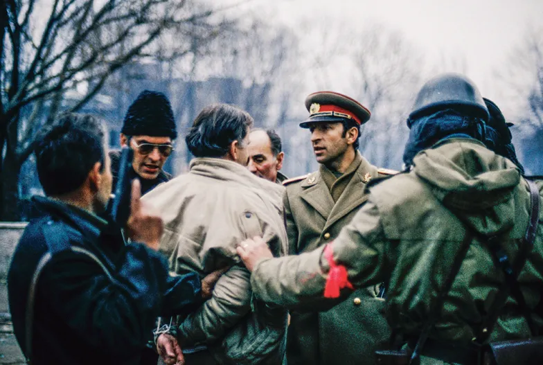 Tajniacy z Securitate prowadzą zatrzymanego demonstranta. Podczas walk, które w grudniu 1989 r. towarzyszyły obaleniu dyktatury, w Rumunii zginęły setki ludzi. / PATRICK ROBERT / CORBIS / GETTY IMAGES