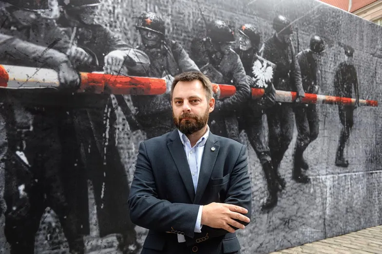 Piotr Bernatowicz, w tle fragmenty instalacji Jerzego Kaliny „Szlaban. Przejścia graniczne” na dziedzińcu Zamku Królewskiego w Warszawie, 17 września 2019 r.