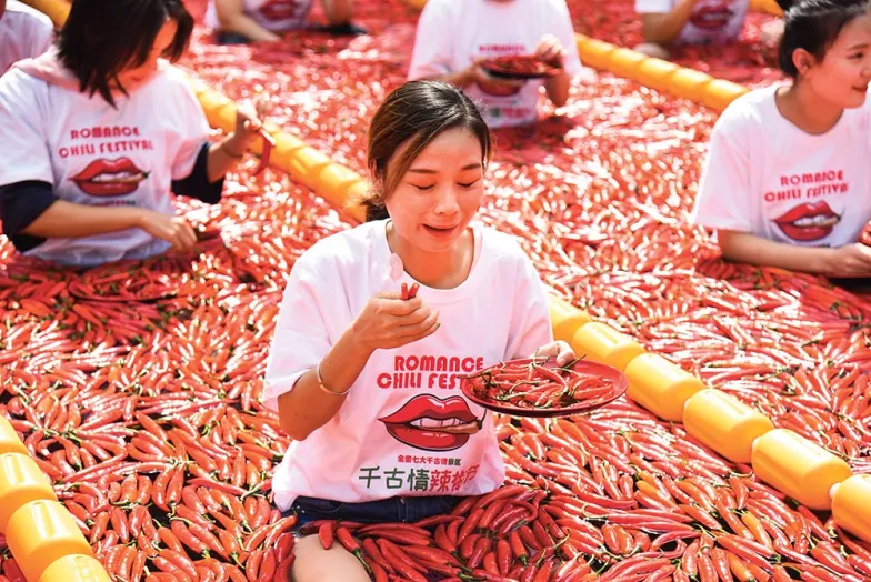 Chińscy turyści biorą udział w zawodach jedzenia papryczek chili. Hangzhou, Chiny, wrzesień 2019 r.