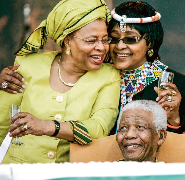 Nelson Mandela na oficjalnych obchodach swoich 90. urodziny. Z lewej Winnie (już jako jego była żona), z prawej ówczesna żona Nelsona, Graça Machel. Pretoria, 2 sierpnia 2008 r. / MICHELLY RALL / WIREIMAGE / GETTY IMAGES 